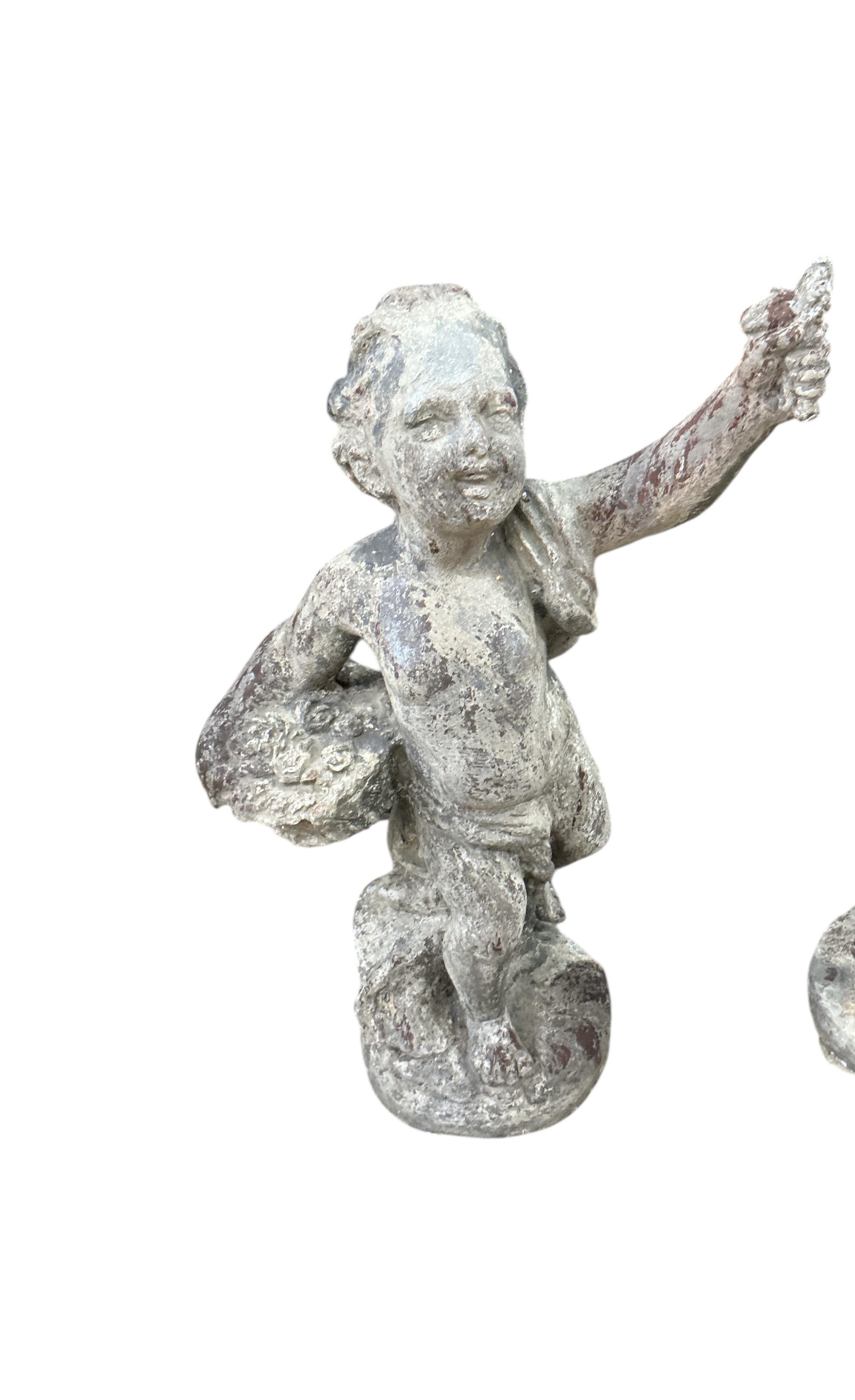 A pair of Victorian lead putti garden ornaments, larger height 48cm
